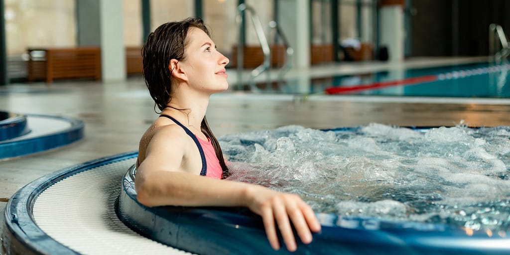 woman relaxing in hot tub at the gym