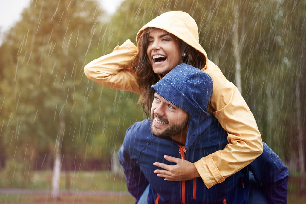 a couple having fun outside in the rain - habits to live more intentionally