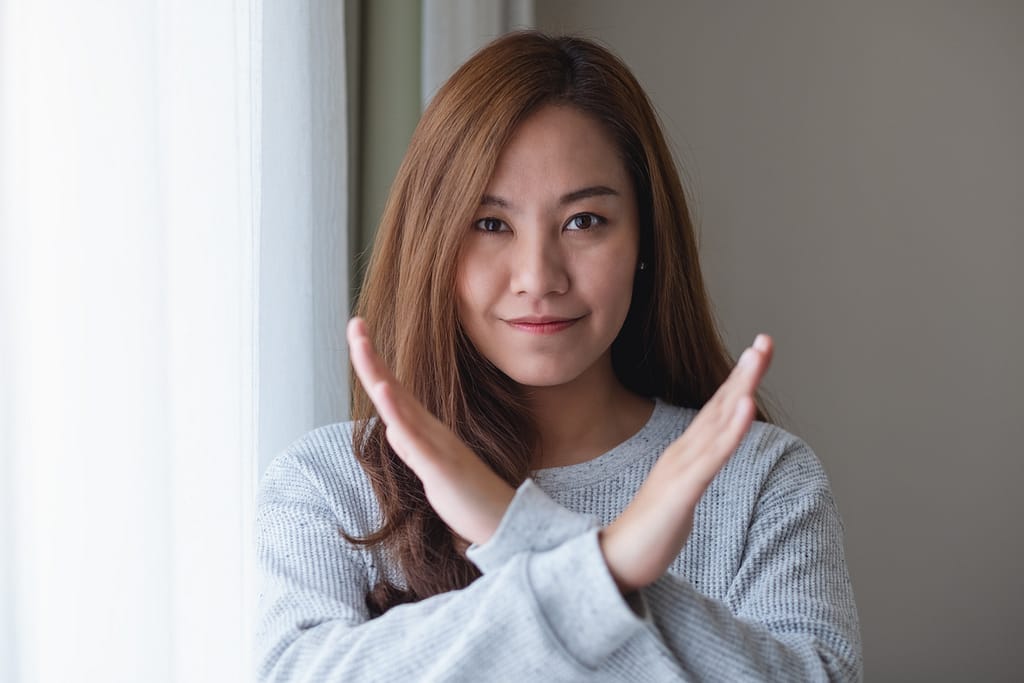 woman making sign of "no" with crossed hands