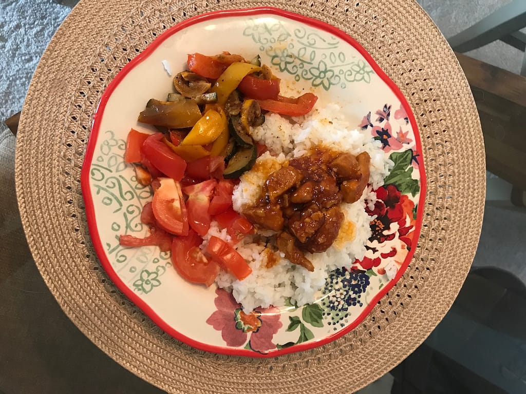 plated orange chicken with rice and vegetables